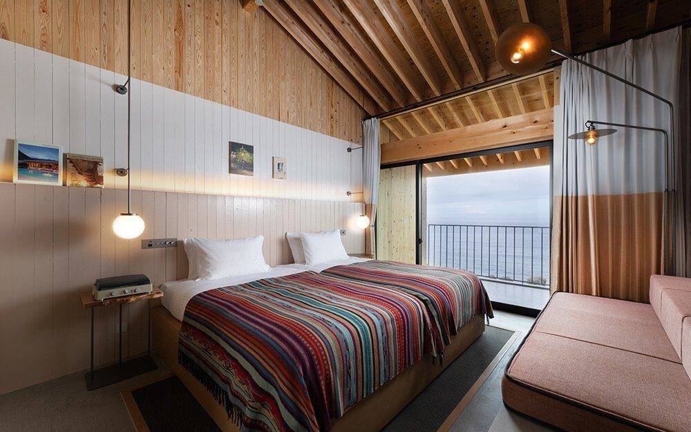 淡路島 KAMOME SLOW HOTEL面海的客房與條紋床罩