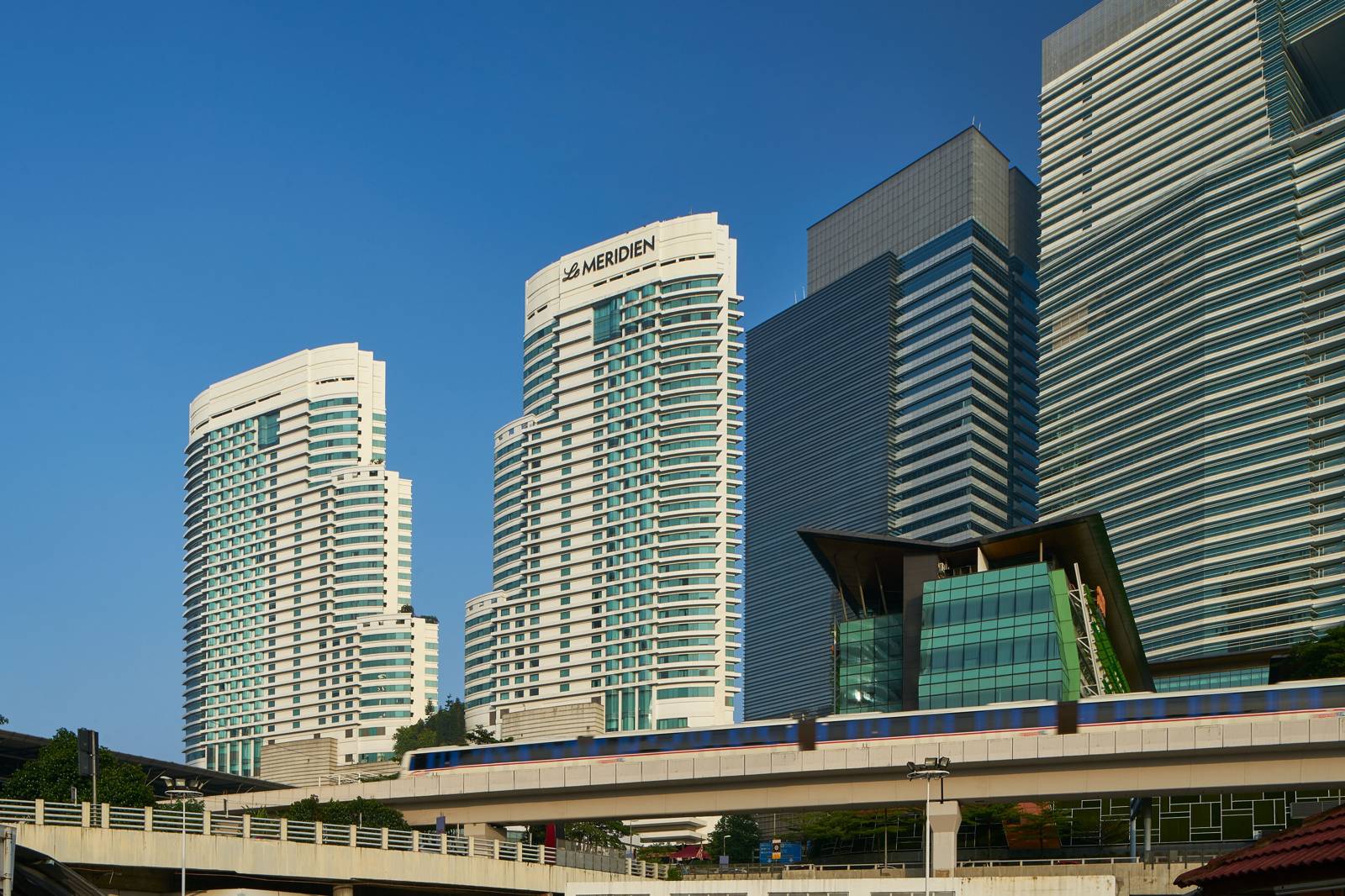 吉隆坡艾美酒店白色塔樓外觀與前方高架單軌列車