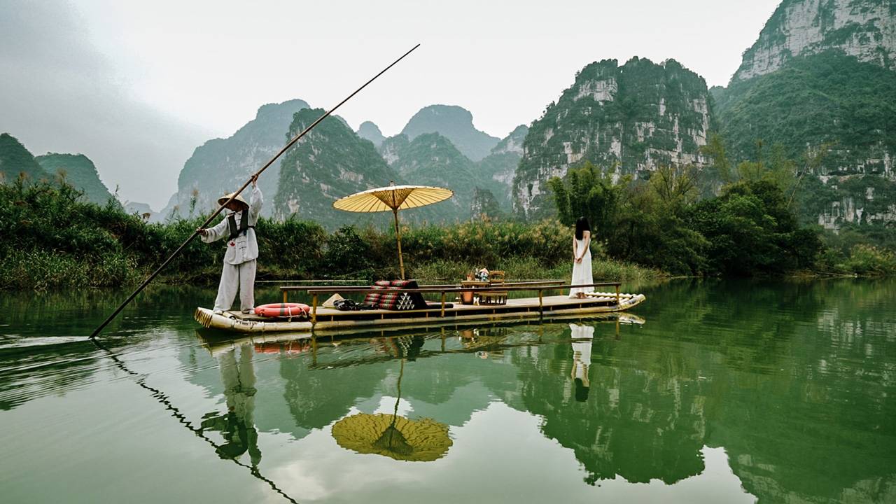 明仕河上撐竹筏的船夫與喀斯特倒影