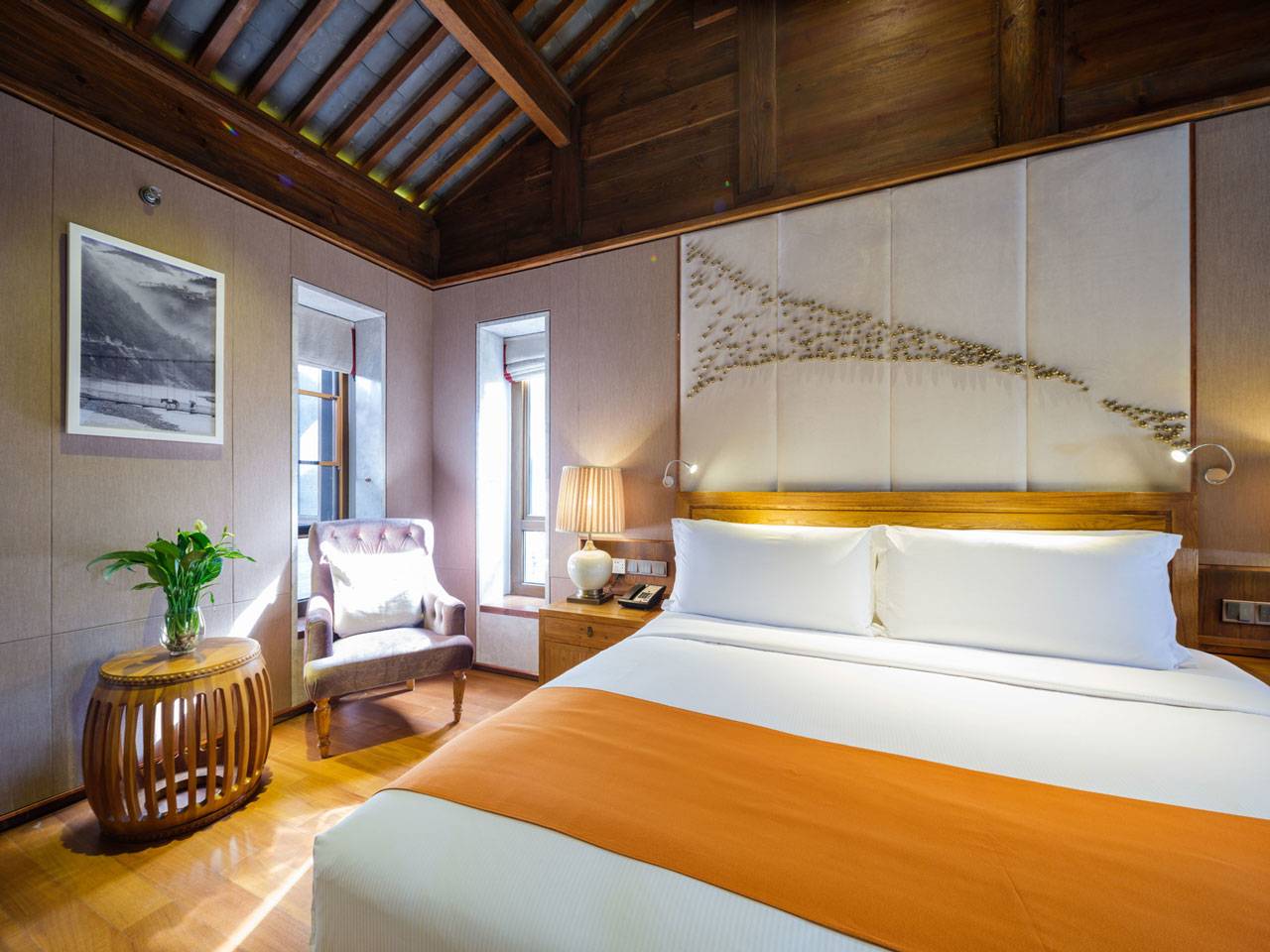麗江 LUX* 酒店 Deluxe Room 的大床與床頭山景畫
