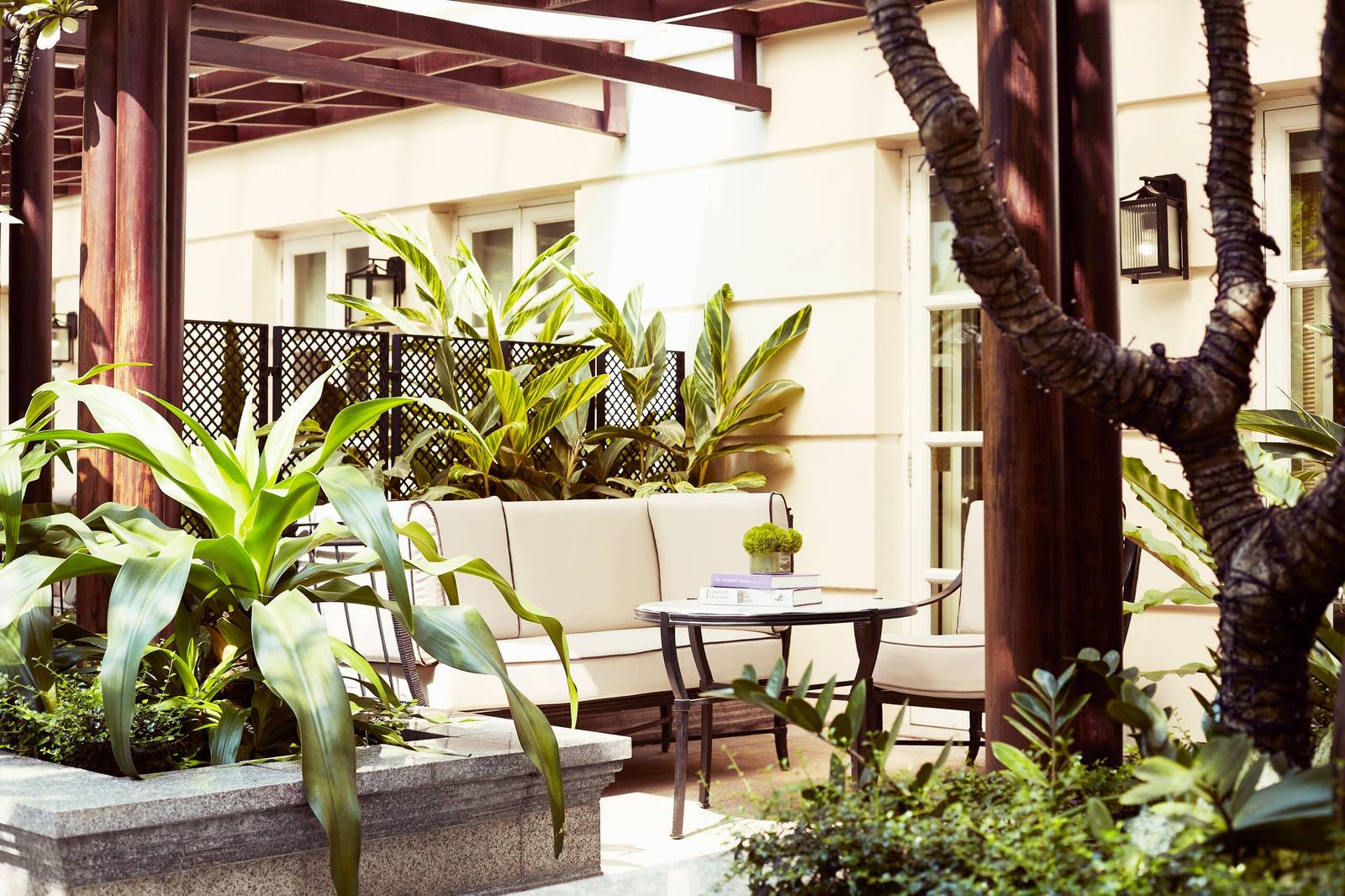 綠色植物圍繞的花園露台與白色沙發