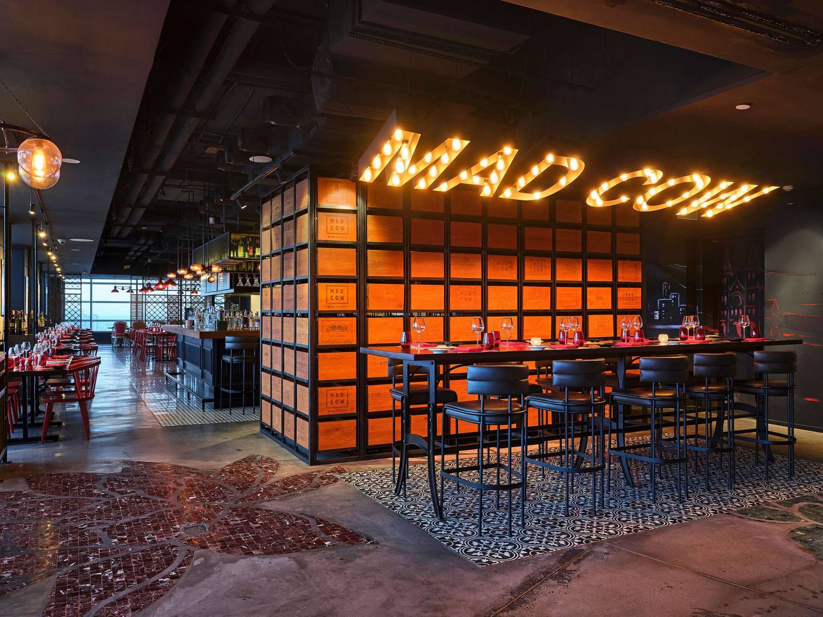 亮著 MAD COW 燈字的餐廳吧檯與座位