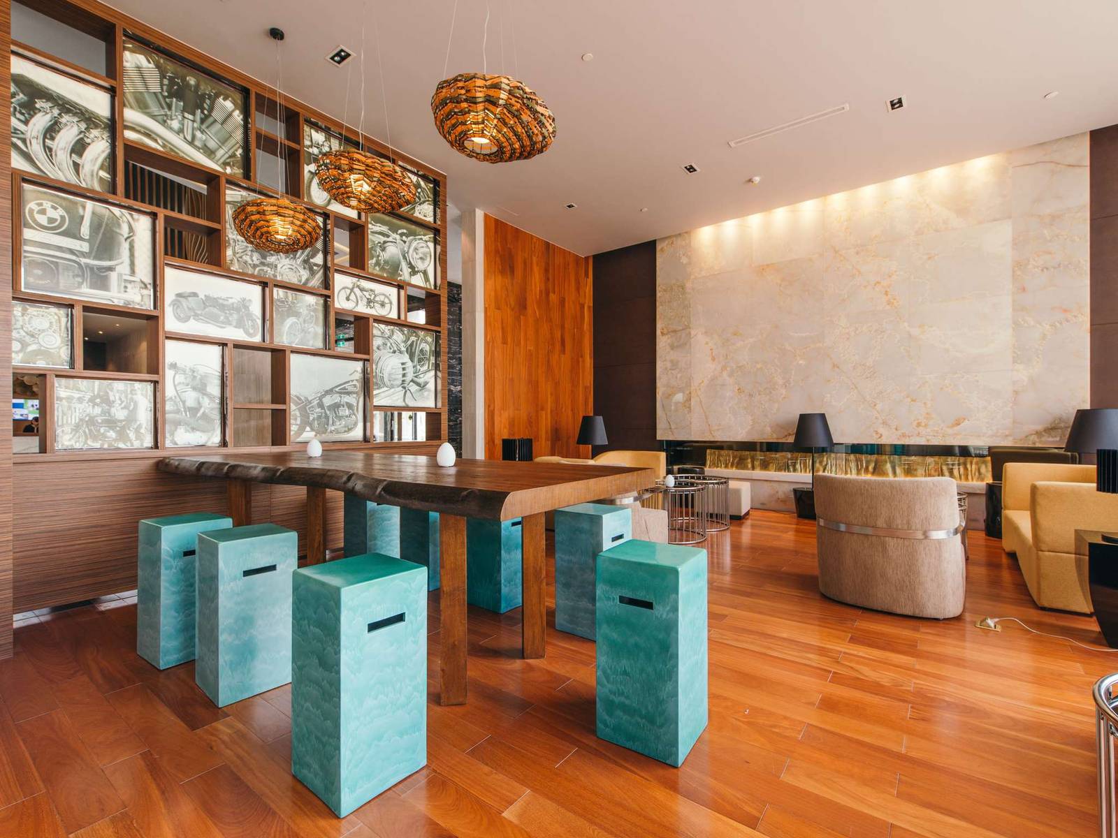 書格牆面、藍綠色方凳與長桌的 Lobby Lounge