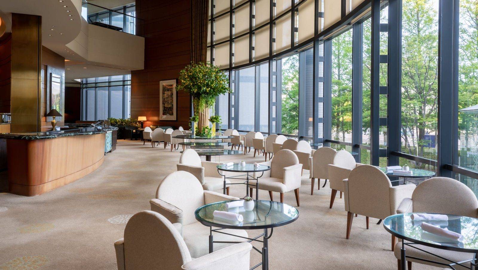 星野集團 RISONARE 大阪 Lobby Lounge 的白色扶手椅與挑高落地窗
