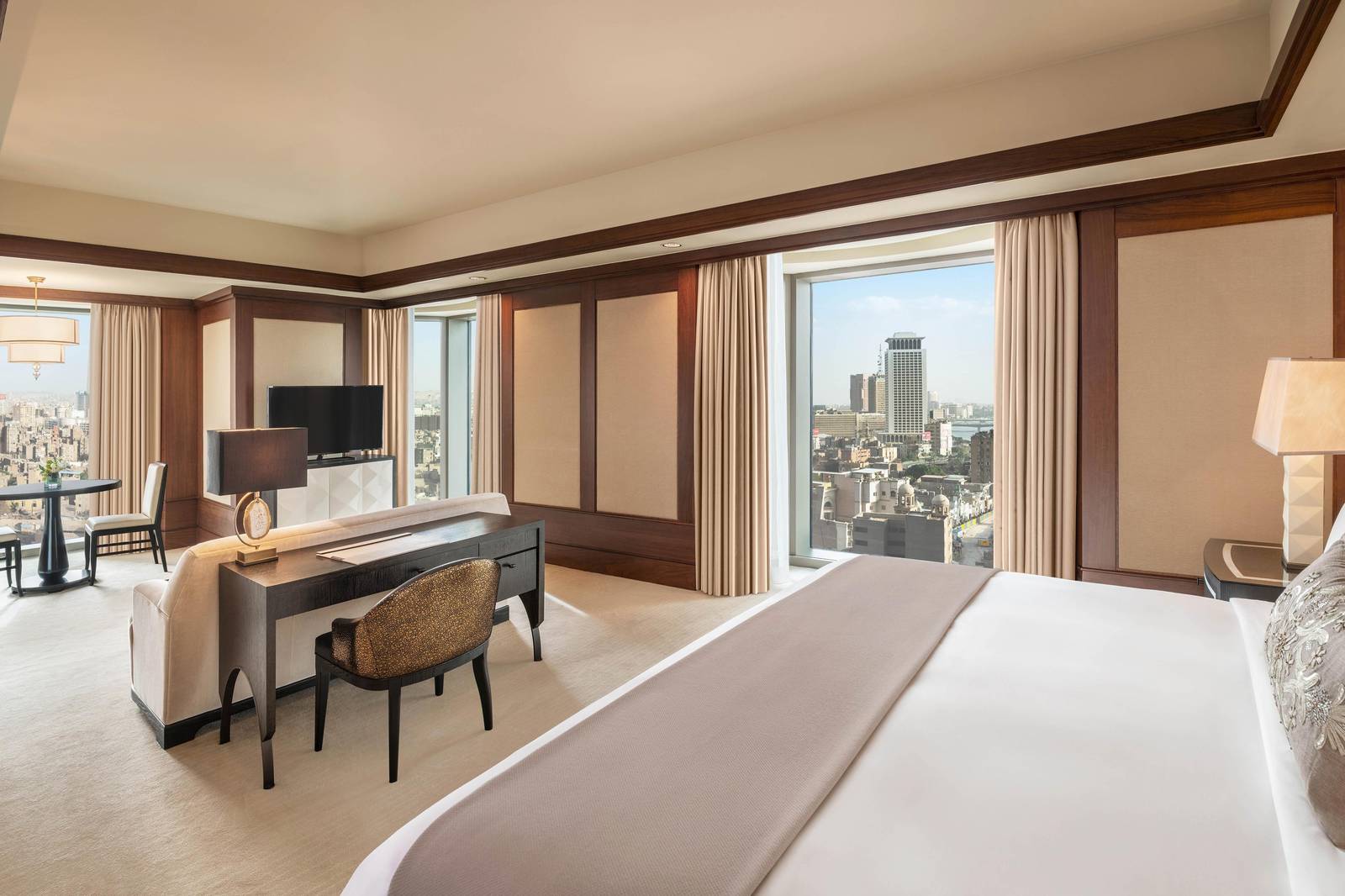 開羅瑞吉酒店 Grand Deluxe Room 的特大床、辦公桌與窗外市景