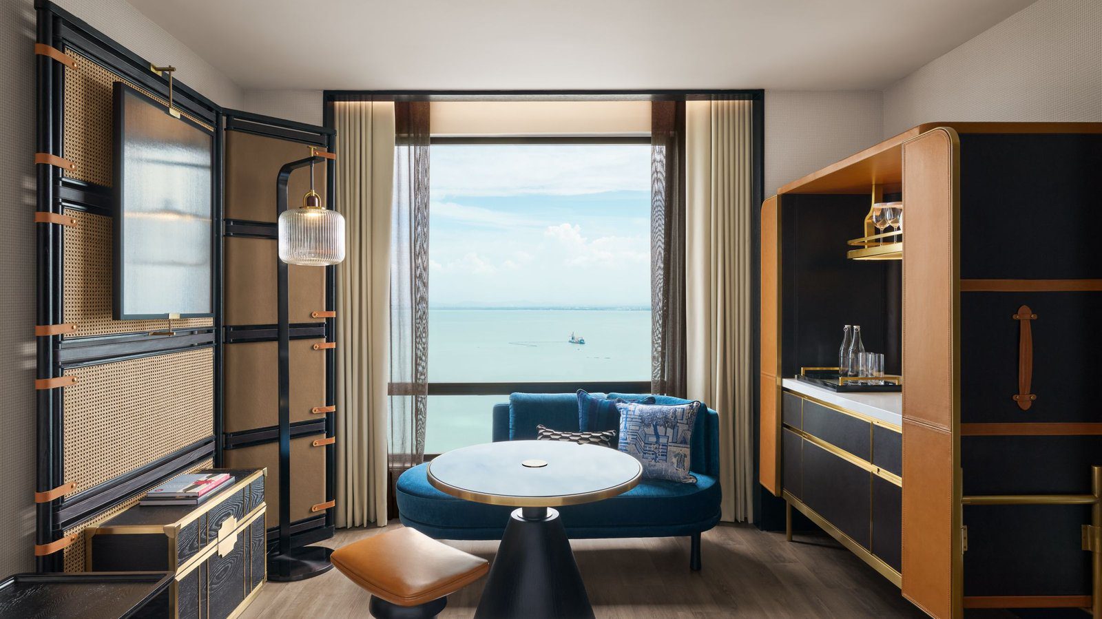 Merchant 客房窗邊的藍色沙發座與海景