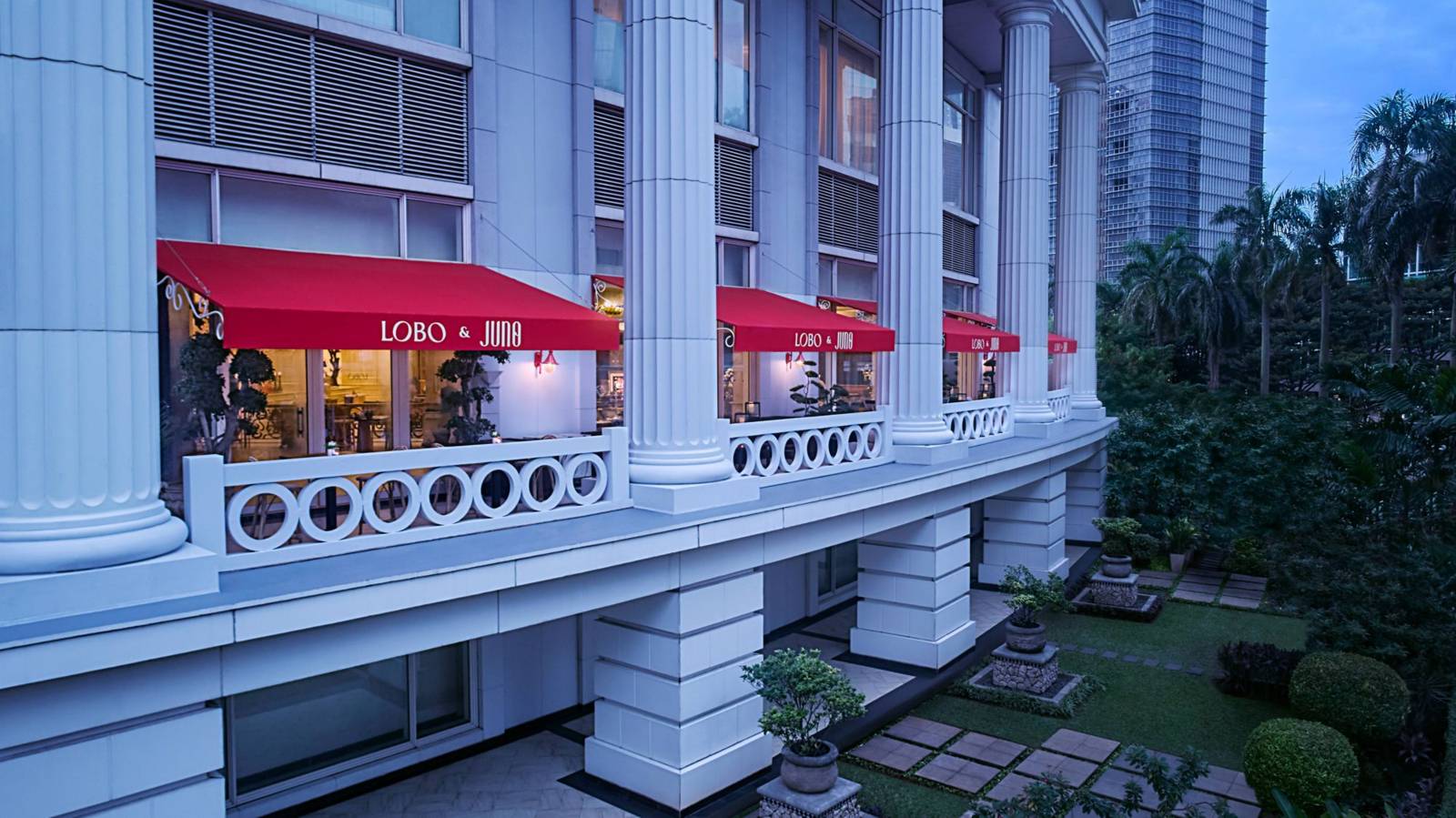 雅加達麥加庫寧安麗思卡爾頓酒店 Lobo 的戶外陽台座位與紅色遮陽篷