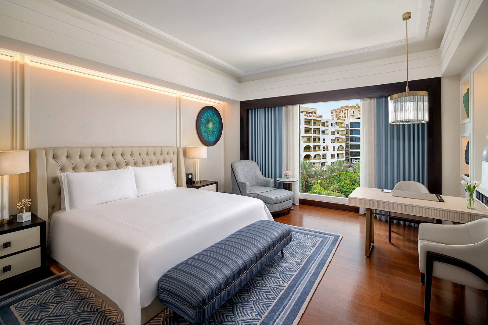 開羅赫里奧波利斯華爾道夫酒店 King Deluxe Room 的大床、扶手椅與落地窗